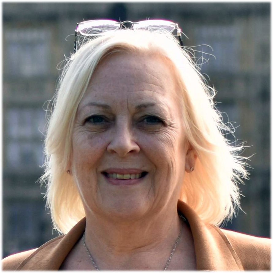 Head and shoulders photo of Sue Willgoss with Parliament buildings in background